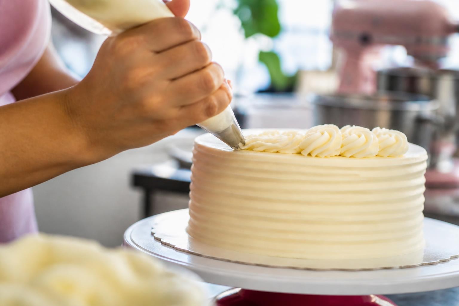 Bolo de pote fotografado com luz natural, ao lado de uma xícara